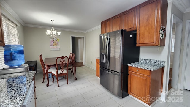 kitchen with crown molding, brown cabinets, stainless steel fridge, and a chandelier