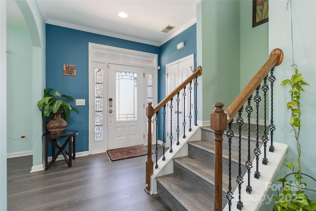 entrance foyer featuring visible vents, baseboards, ornamental molding, and dark wood-style flooring