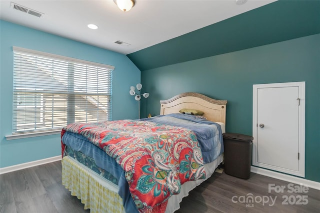 bedroom featuring visible vents, lofted ceiling, baseboards, and wood finished floors