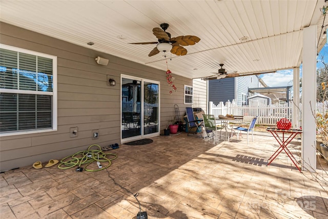 view of patio featuring outdoor dining area, a ceiling fan, and fence