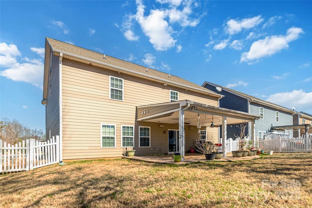 back of property featuring a lawn, a patio, and fence