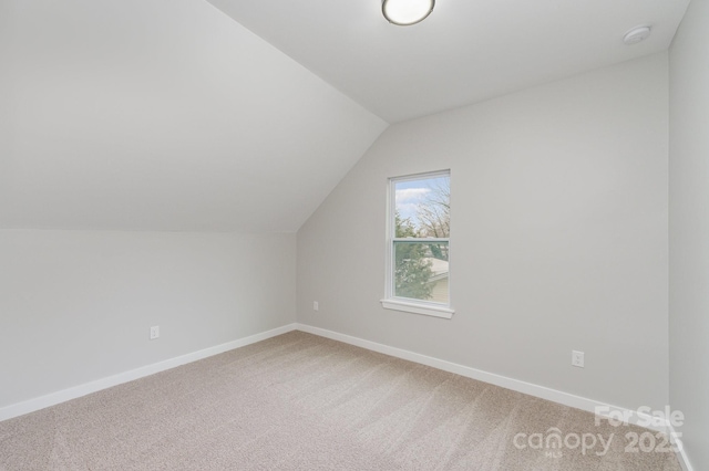 bonus room with baseboards, light colored carpet, and lofted ceiling