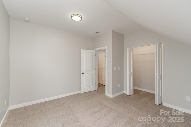 unfurnished bedroom with baseboards, carpet flooring, lofted ceiling, and visible vents
