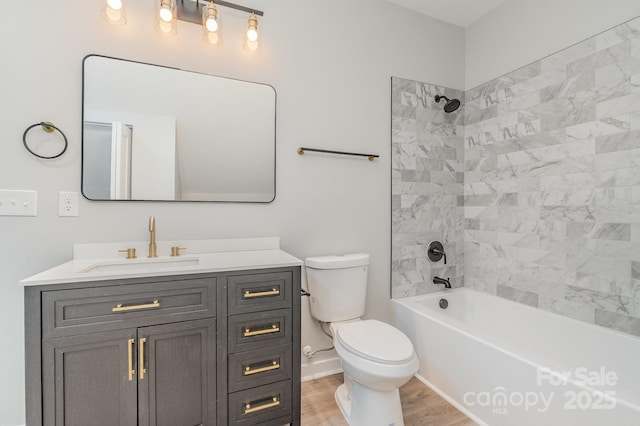 bathroom with vanity, wood finished floors, toilet, baseboards, and shower / bath combination