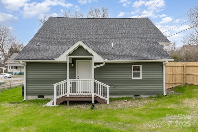 back of house featuring a lawn, crawl space, fence, and a shingled roof