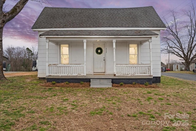 bungalow-style house featuring covered porch and a shingled roof