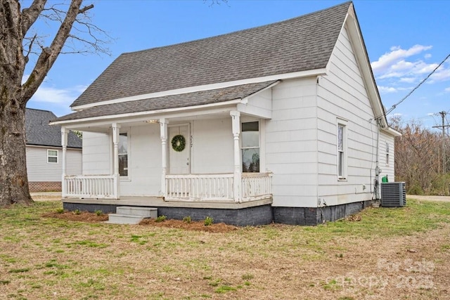 bungalow with covered porch, a shingled roof, a front lawn, and cooling unit