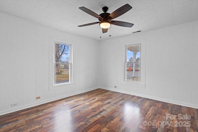 spare room with baseboards, visible vents, ceiling fan, and hardwood / wood-style floors