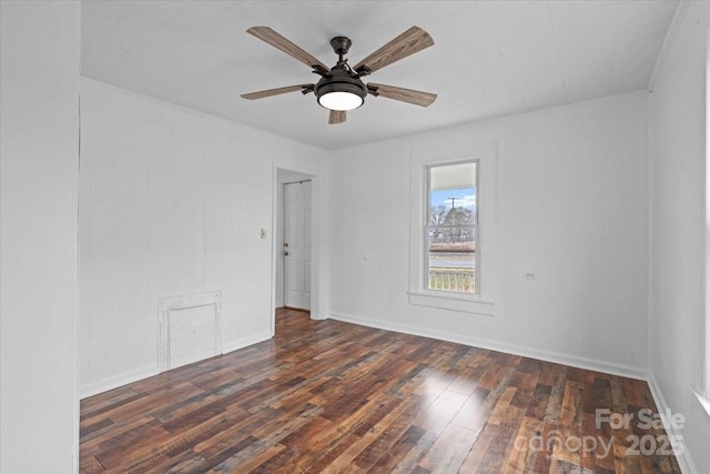 empty room featuring wood finished floors, a ceiling fan, and baseboards