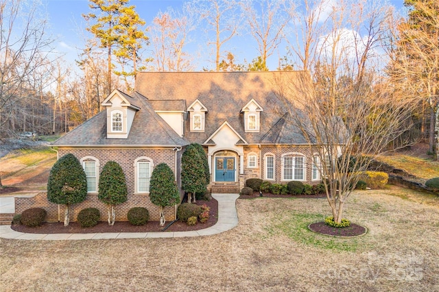 view of front of house with brick siding and a front lawn