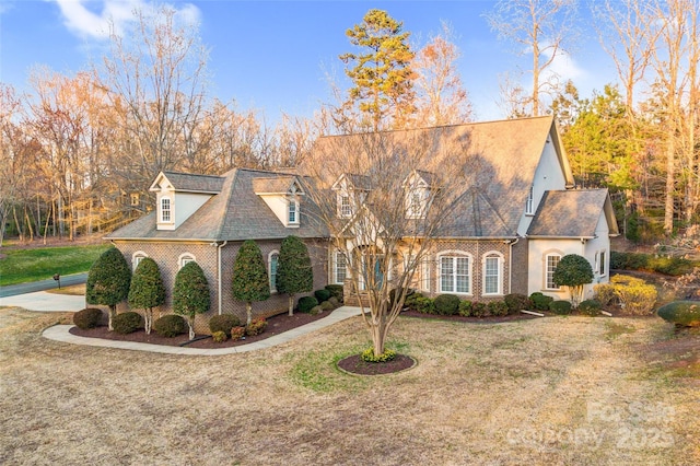 view of front facade featuring brick siding and a front yard