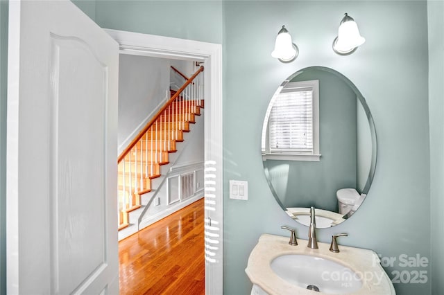 half bathroom featuring a sink and wood finished floors