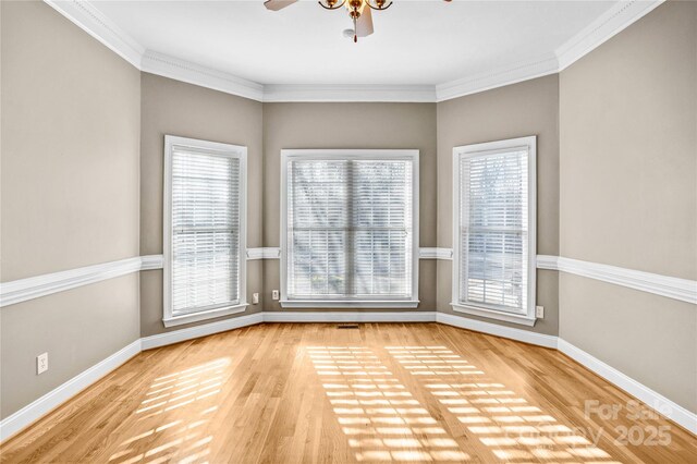 spare room with a wealth of natural light, baseboards, and wood finished floors