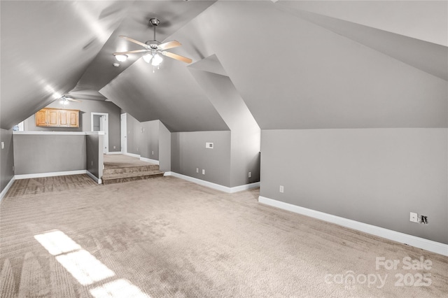 additional living space featuring baseboards, light carpet, lofted ceiling, and ceiling fan