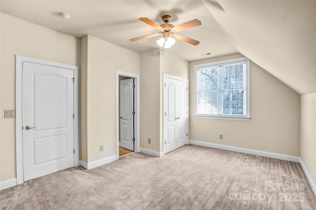 unfurnished bedroom with vaulted ceiling, carpet flooring, and baseboards