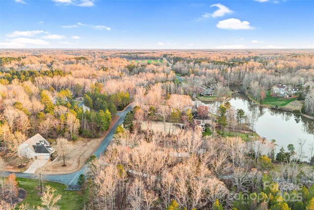 drone / aerial view featuring a forest view and a water view