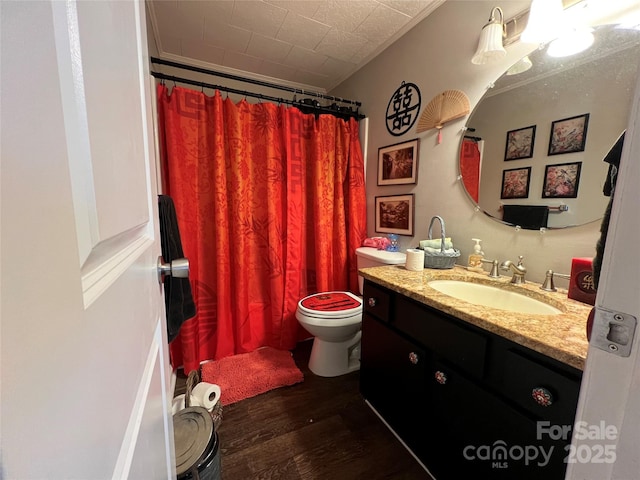 bathroom with toilet, a shower with shower curtain, wood finished floors, and vanity