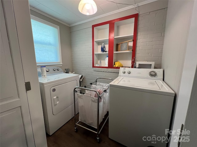 washroom featuring dark wood-type flooring, laundry area, ornamental molding, and washing machine and clothes dryer