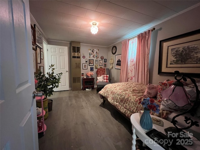 bedroom featuring ornamental molding and wood finished floors