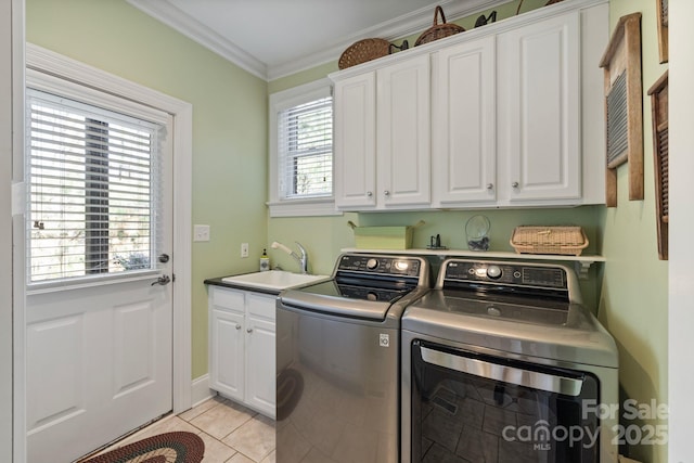 laundry area featuring ornamental molding, light tile patterned floors, washer and dryer, cabinet space, and a sink