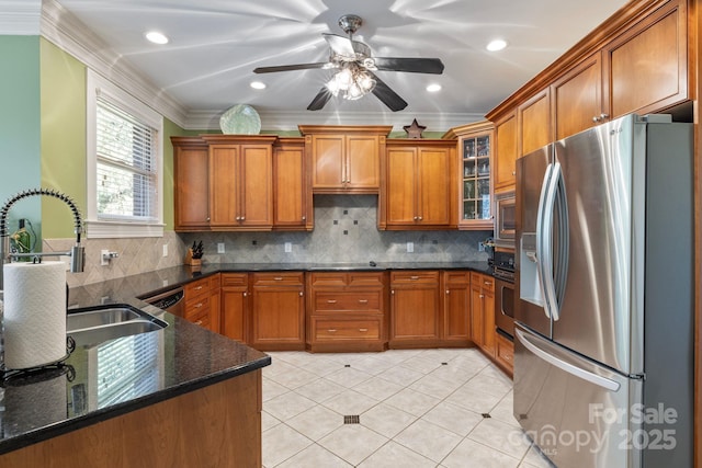 kitchen with ornamental molding, a sink, tasteful backsplash, appliances with stainless steel finishes, and brown cabinetry