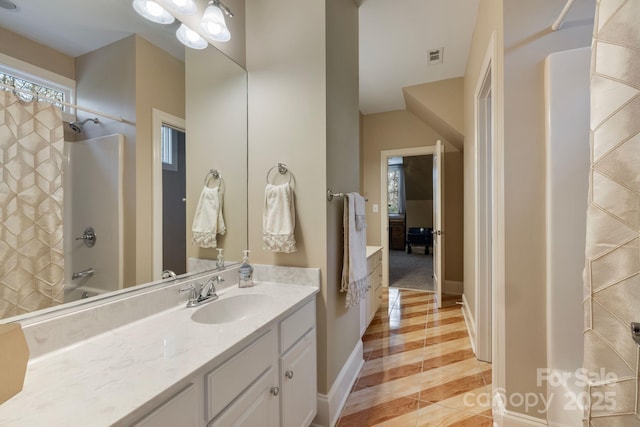 bathroom featuring vanity, baseboards, visible vents, bathing tub / shower combination, and tile patterned floors