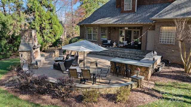 view of patio with outdoor dry bar, area for grilling, and an outdoor hangout area