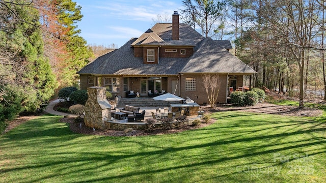 back of property with a patio, area for grilling, a yard, and a chimney