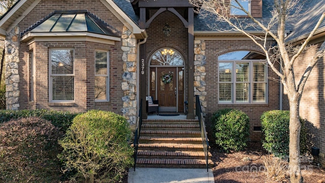 entrance to property with a standing seam roof, metal roof, a shingled roof, crawl space, and brick siding