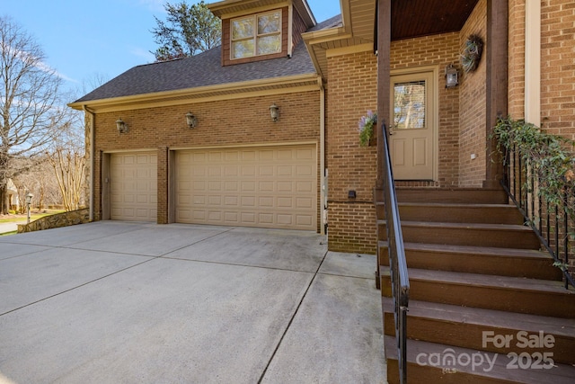 exterior space with brick siding, concrete driveway, a garage, and roof with shingles