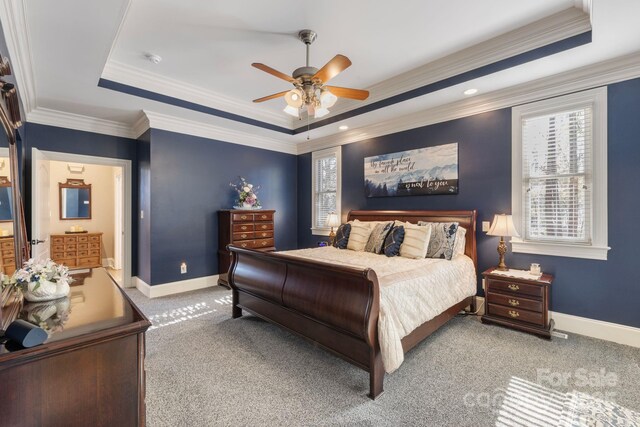 bedroom with a tray ceiling, baseboards, ornamental molding, and carpet flooring