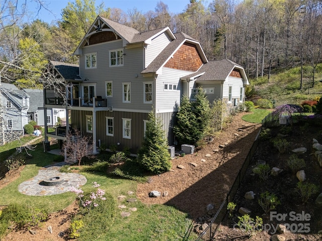 14 Twinflower Trl, Asheville, NC 28804 - back of property featuring a fire pit, a sunroom, and roof with shingles