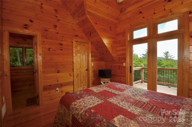 bedroom with access to outside and wooden walls