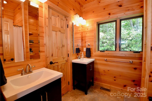 full bathroom with visible vents, wood walls, vanity, and a shower with curtain