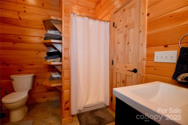 full bathroom featuring toilet, wood walls, a shower with curtain, and vanity