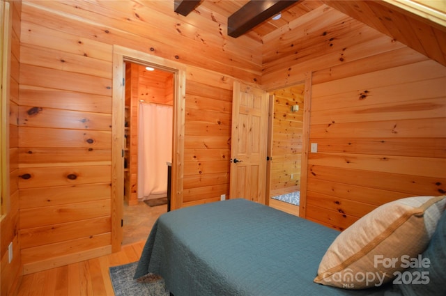 bedroom with wooden ceiling, beamed ceiling, wooden walls, and wood finished floors