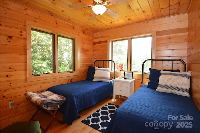 bedroom with wood ceiling, wood walls, and light wood-style flooring