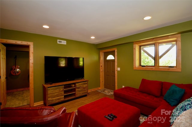 living room with recessed lighting, visible vents, baseboards, and wood finished floors