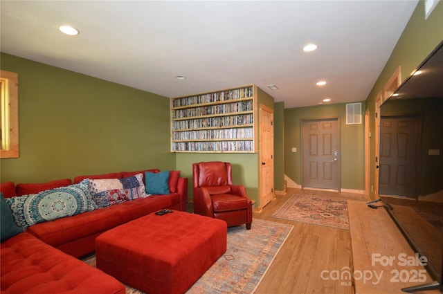 living area with recessed lighting, visible vents, light wood-style flooring, and baseboards