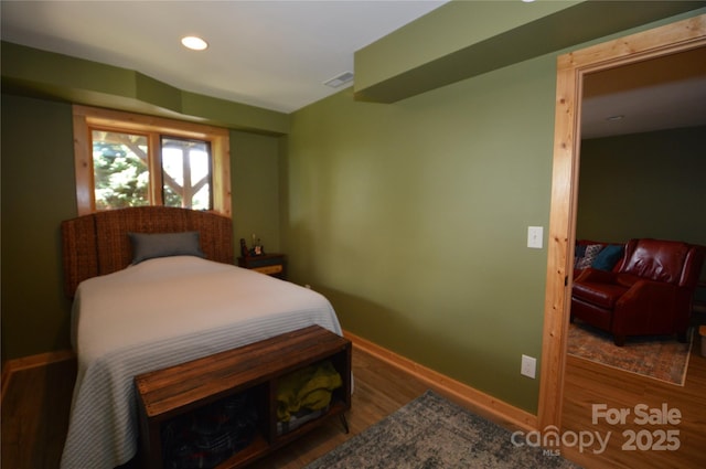 bedroom with recessed lighting, visible vents, baseboards, and wood finished floors