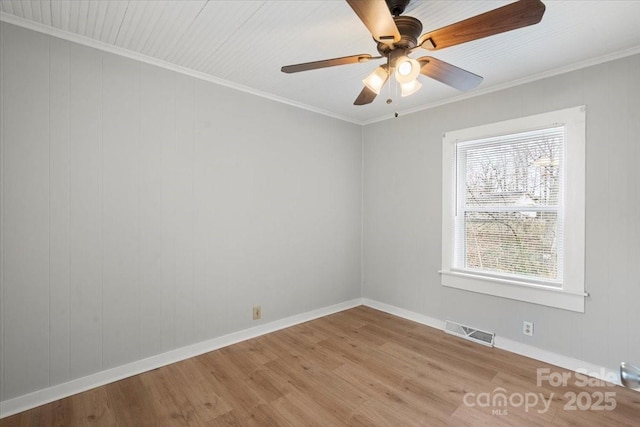 empty room featuring ornamental molding, wood finished floors, and visible vents