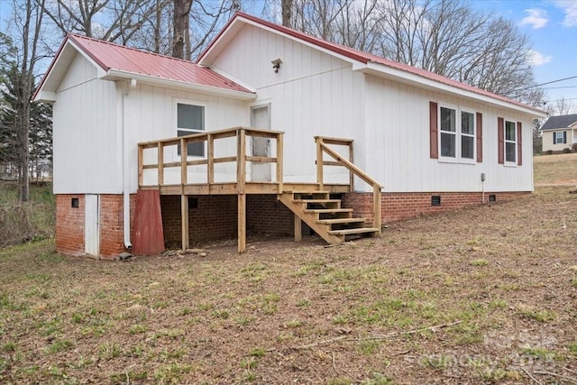 rear view of property featuring crawl space, metal roof, a deck, and stairs