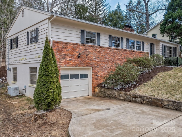 view of front of home featuring concrete driveway, brick siding, a chimney, and an attached garage