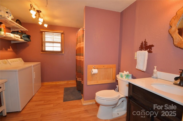 bathroom featuring toilet, wood finished floors, independent washer and dryer, curtained shower, and vanity