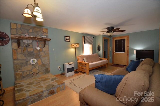 living room with ceiling fan, baseboards, and wood finished floors