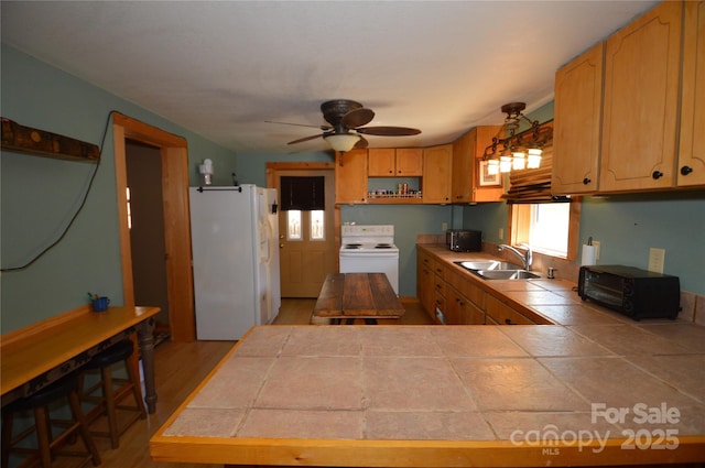 kitchen featuring white appliances, tile countertops, a peninsula, open shelves, and a sink