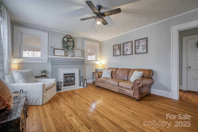 living room with ceiling fan, baseboards, light wood-style flooring, and crown molding