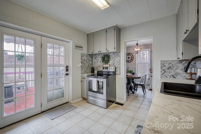 kitchen with stainless steel electric range oven, light tile patterned floors, gray cabinetry, a sink, and light countertops