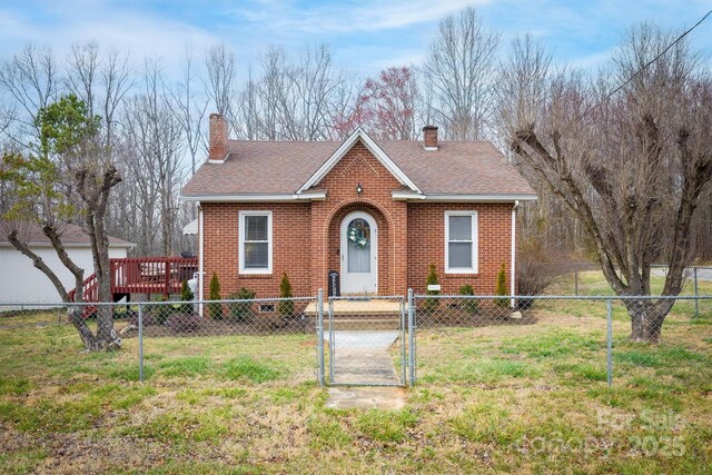 bungalow-style house with brick siding, fence private yard, a front yard, and a gate