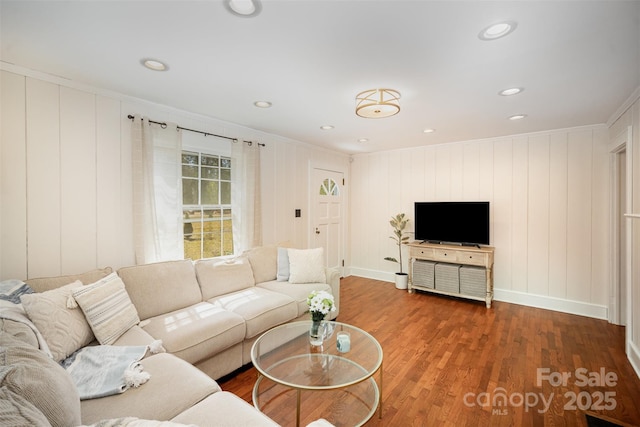 living area featuring baseboards, wood finished floors, recessed lighting, and crown molding